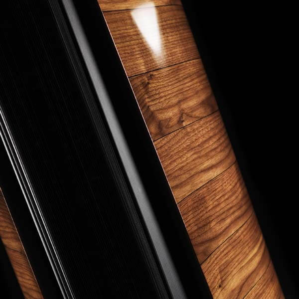 Close-up of Sonus faber's Aida floorstanding loudspeaker in Walnut high gloss finish with black leather detailing.